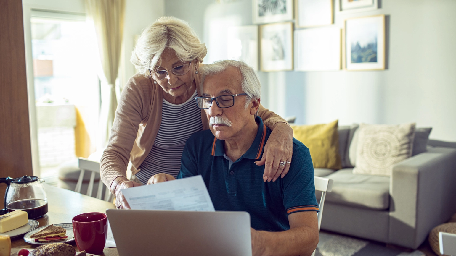 Elderly couple checking their document in their dining table Elderly couple checking their document in their dining table