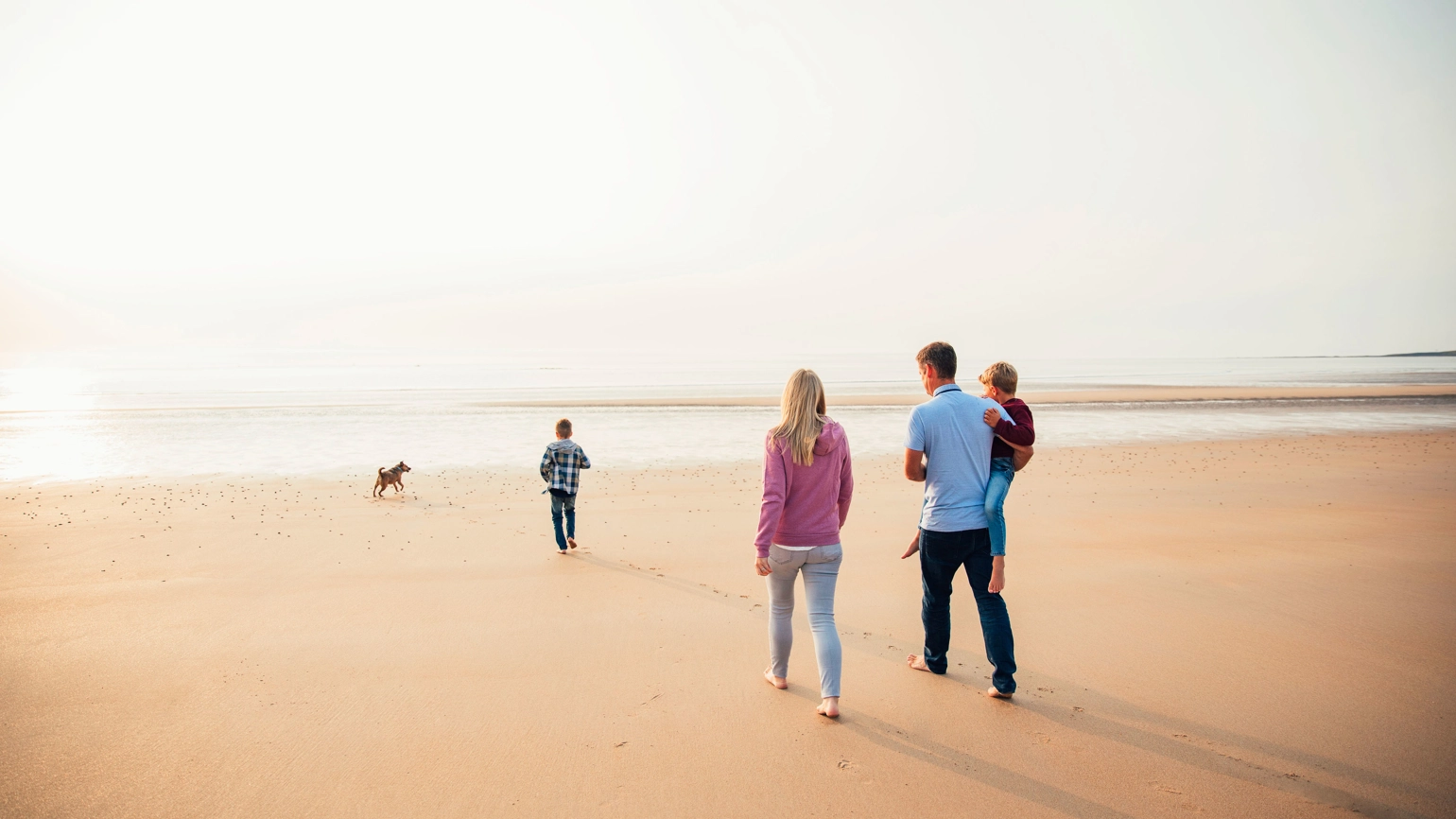 Family and the dog walking in the beach Family and the dog walking in the beach