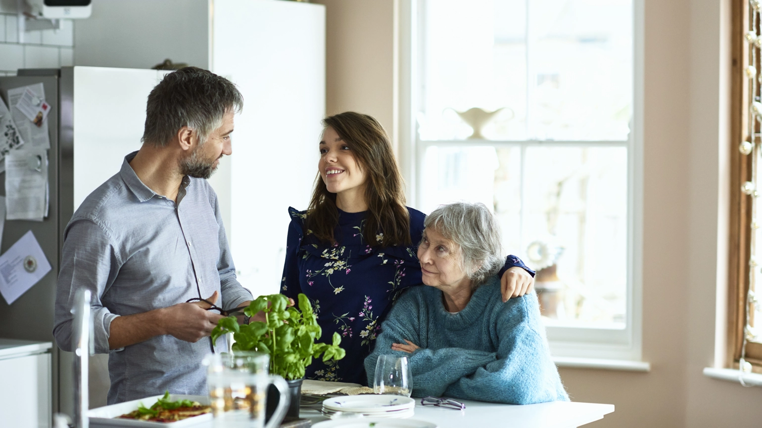 Elderly couple and their daughter in the kitchen chatting Elderly couple and their daughter in the kitchen chatting